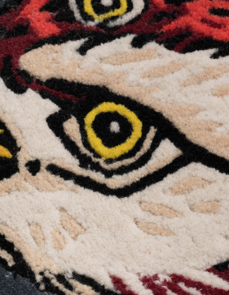 Close-up of a cartoonish character's face with red hair and yellow eyes on a textured surface.