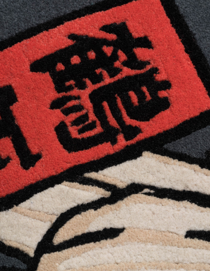 Close-up of a rug with black text on a red background