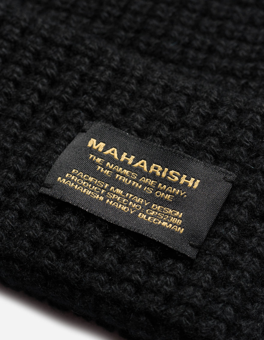 Black knit fabric with a visible label on a black background