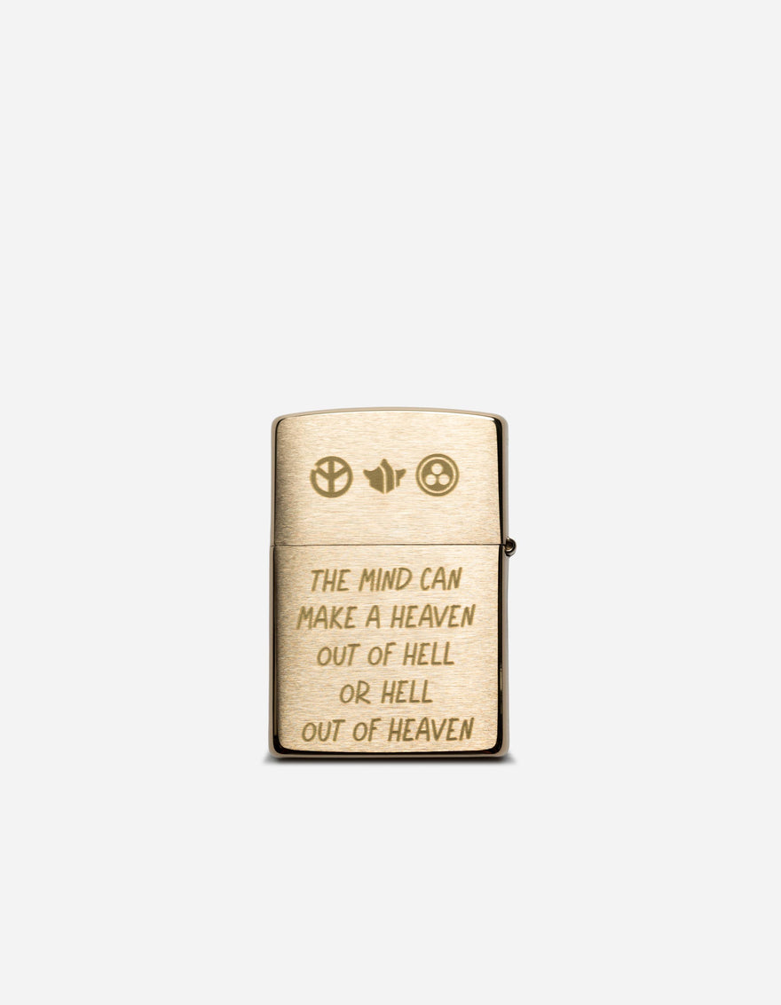 Gold lighter with engraved text and symbols on a white background