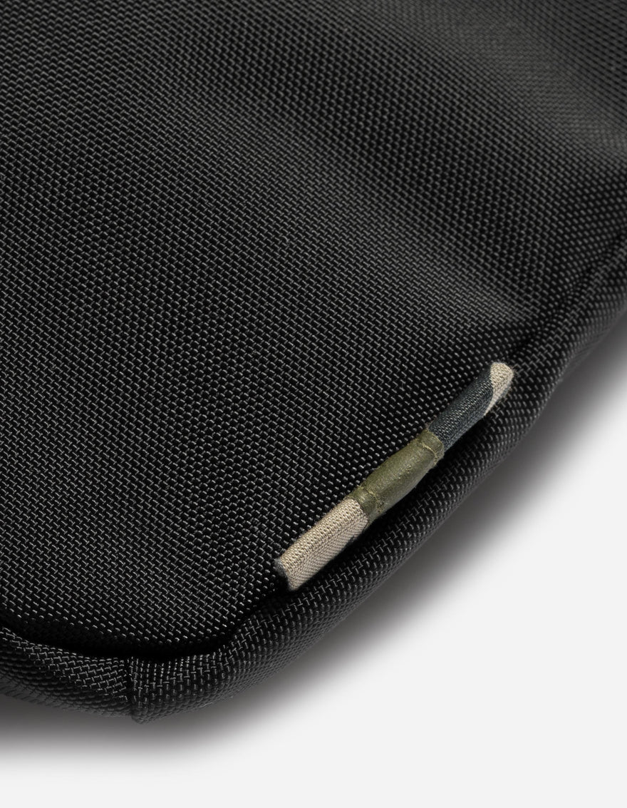 Close-up of a black fabric surface with a small green tag.