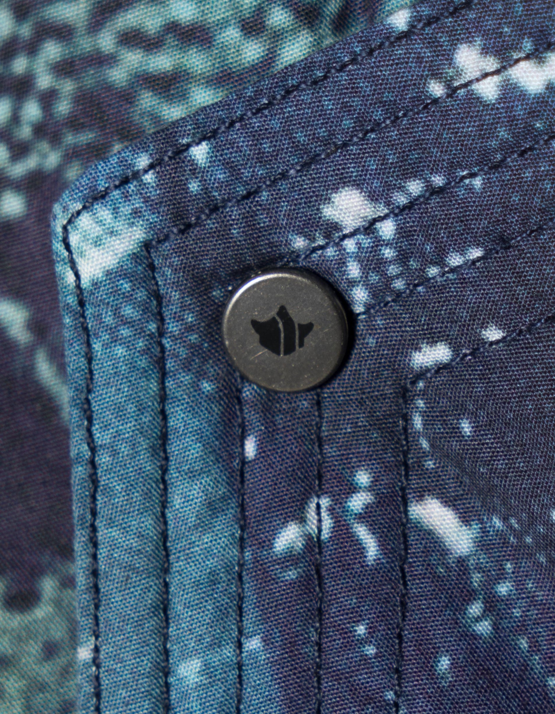 embroidered detailing on a jacket with maharishi logo button