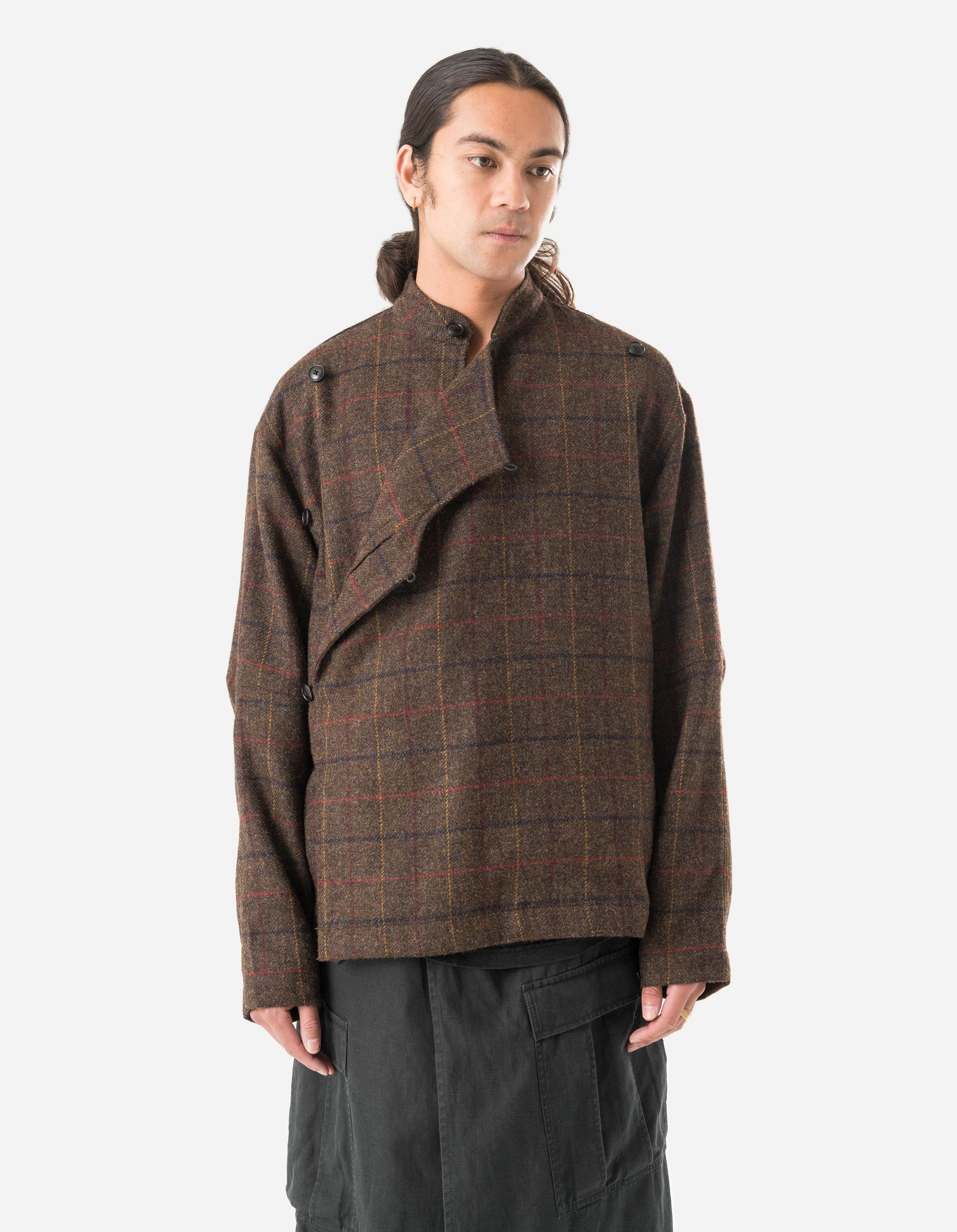 Person wearing a brown plaid jacket on a white background