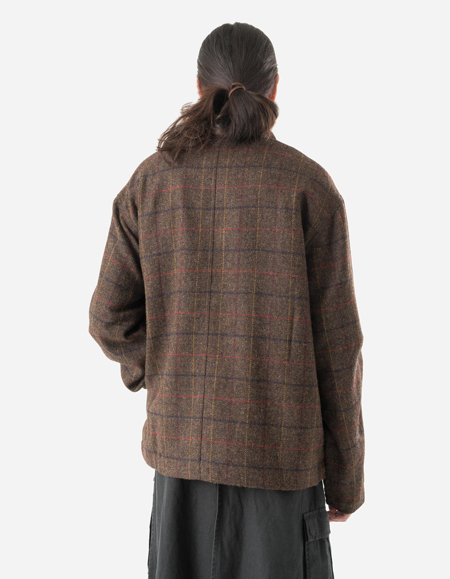 Person wearing a brown plaid jacket on a white background