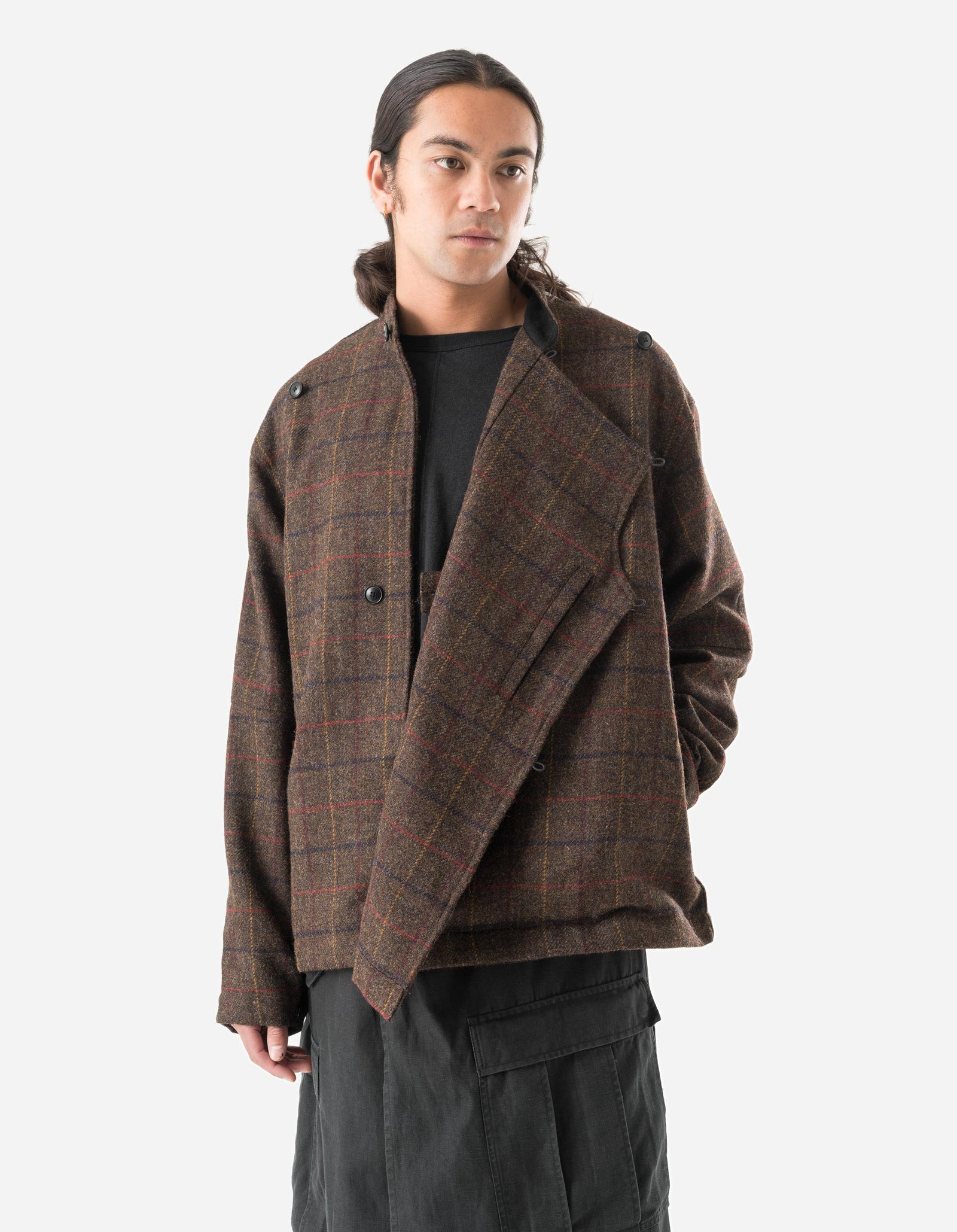 Person wearing a brown plaid jacket on a white background