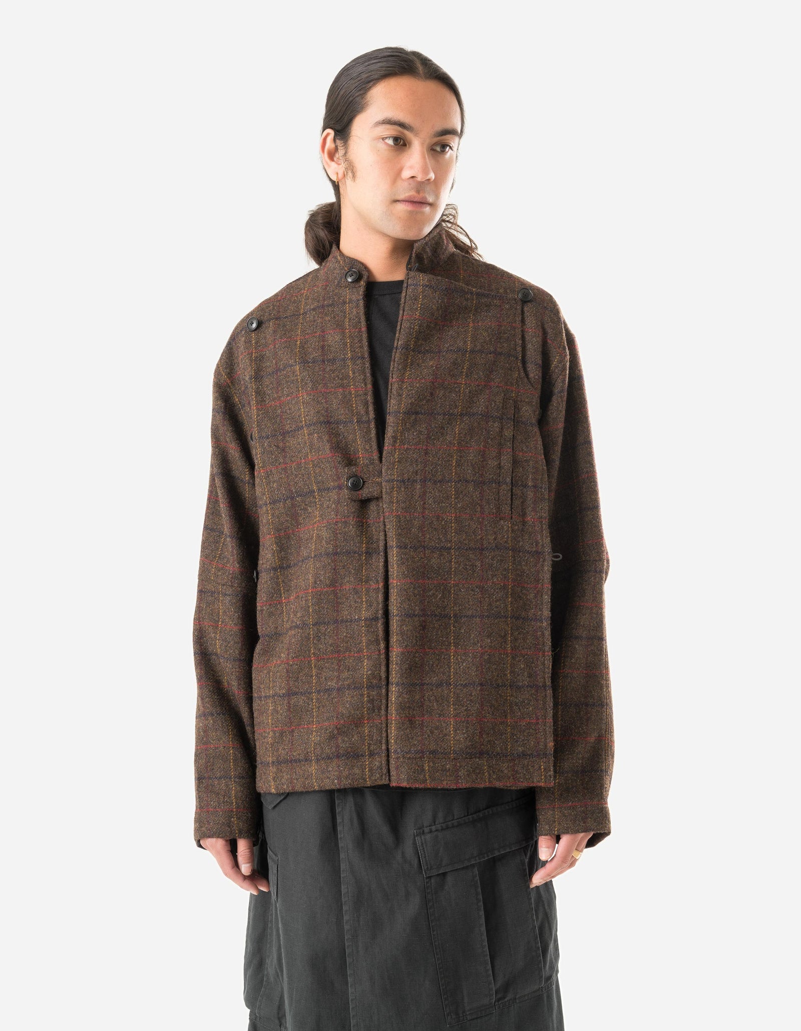Person wearing a brown plaid jacket on a white background