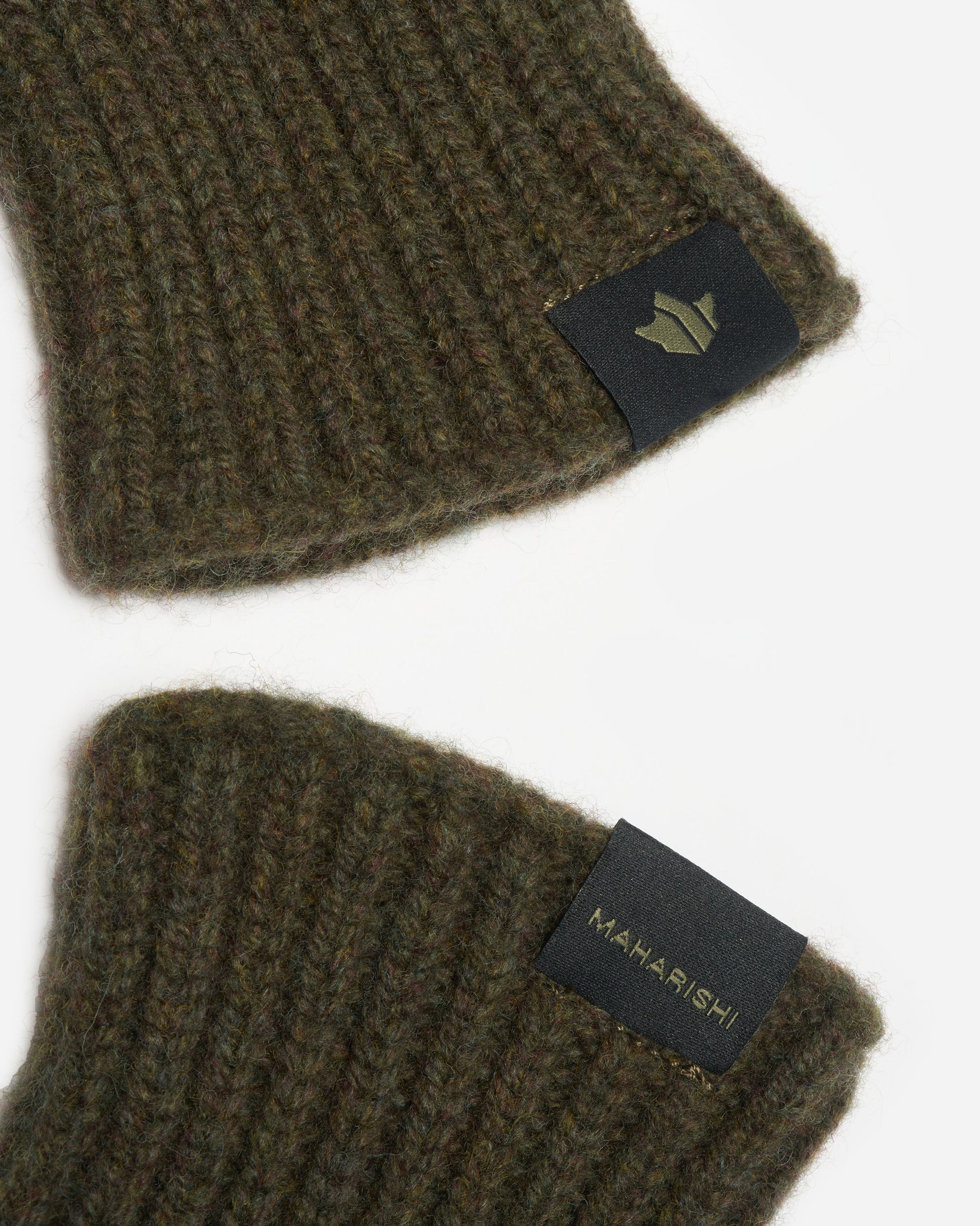 Two green knit hats with visible brand labels on a white background