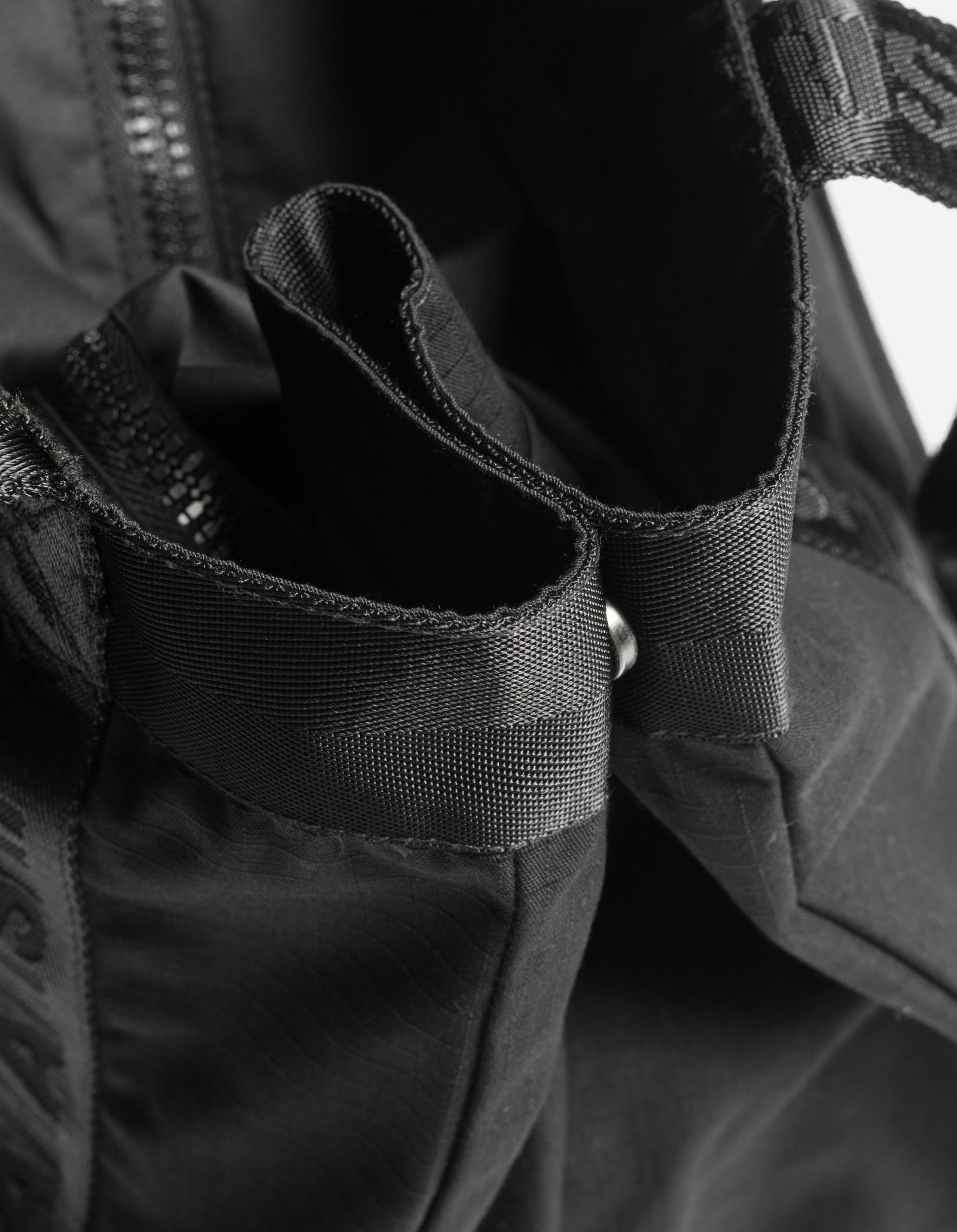 Close-up of a black backpack with straps and zippers.