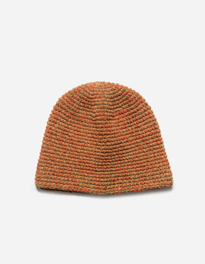 Knitted beanie in orange and green on a light gray background