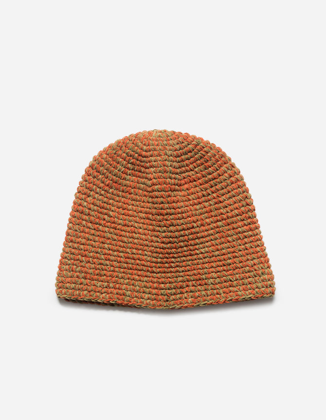 Knitted beanie in orange and green on a light gray background