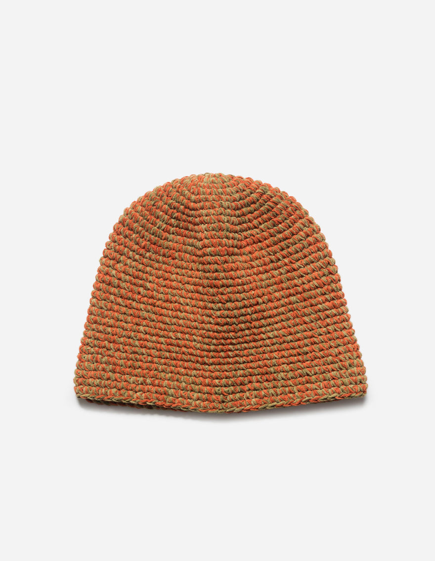 Knitted beanie in orange and green on a light gray background