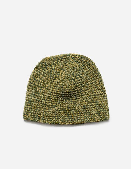 Green knitted beanie on a light gray background
