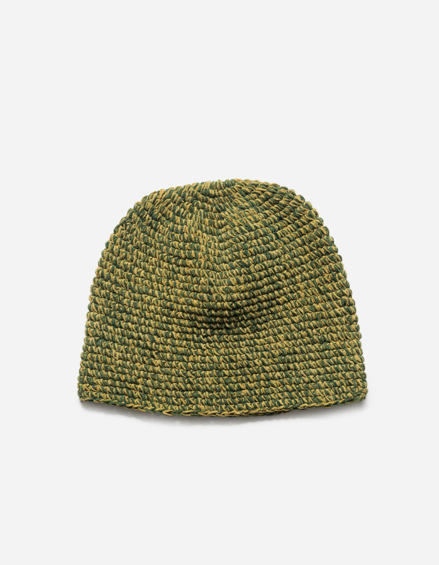 Green knitted beanie on a light gray background