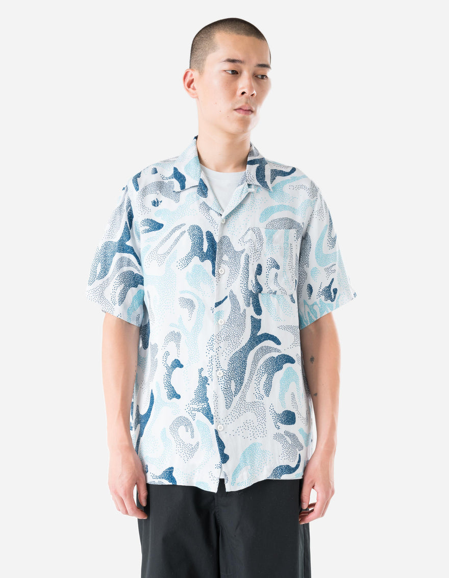 Person wearing a patterned shirt with a white background
