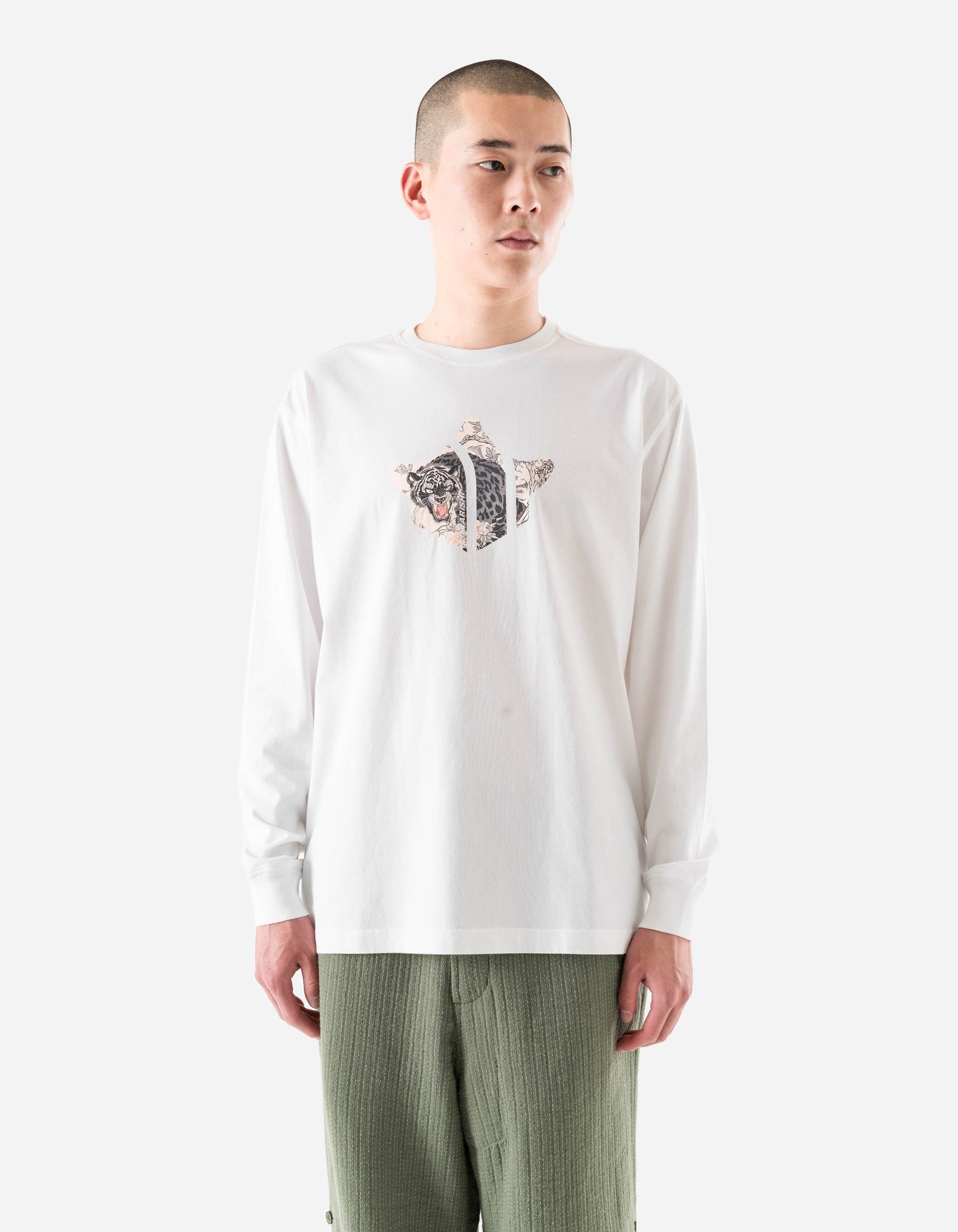 Person wearing a white long-sleeve shirt with a graphic design on a plain background