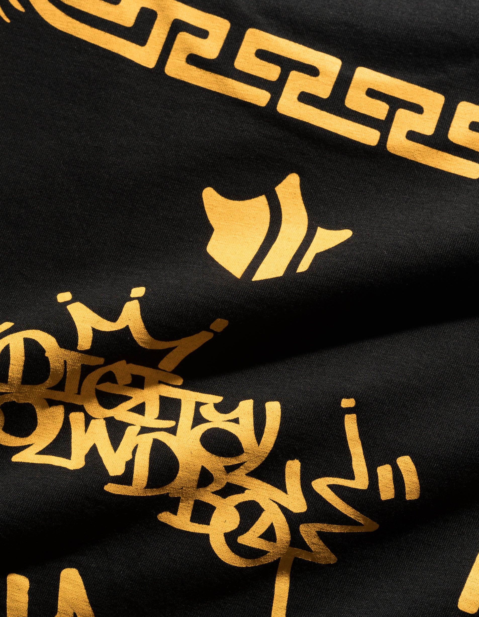 Black fabric with gold geometric patterns and text