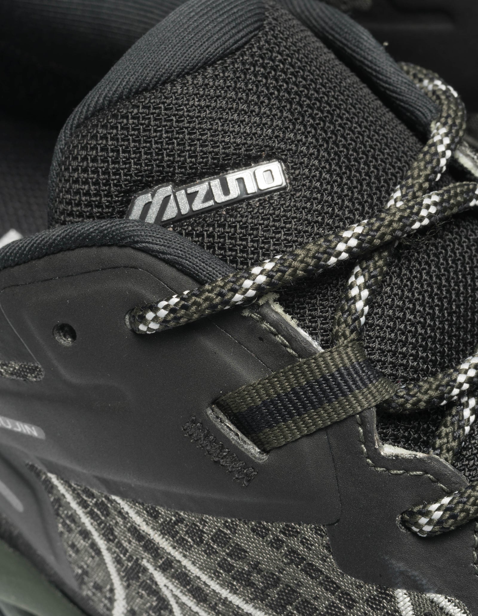 Close-up of a black athletic shoe with Mizuno branding.