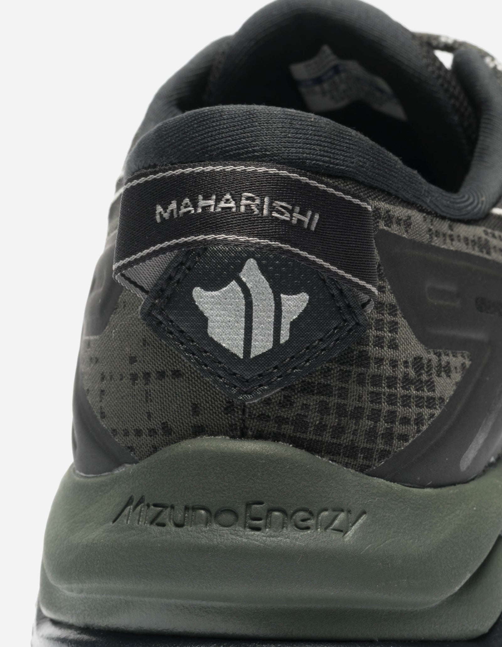 Close-up of a sneaker with 'Maharishi' branding and 'Mizuno Energy' text on a white background.