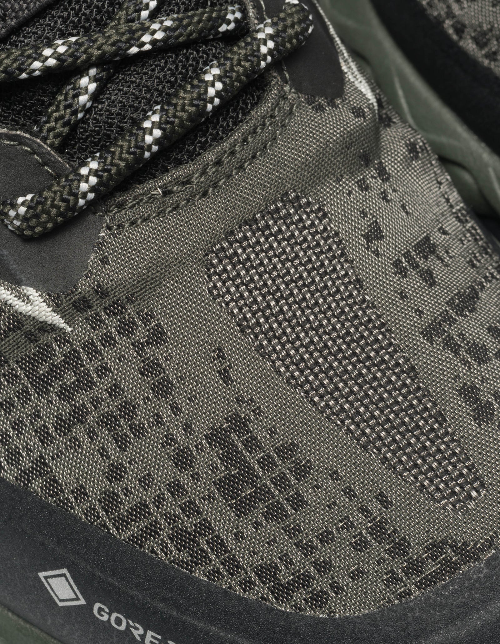 Close-up of a green hiking shoe with textured sole and Gore-Tex logo.