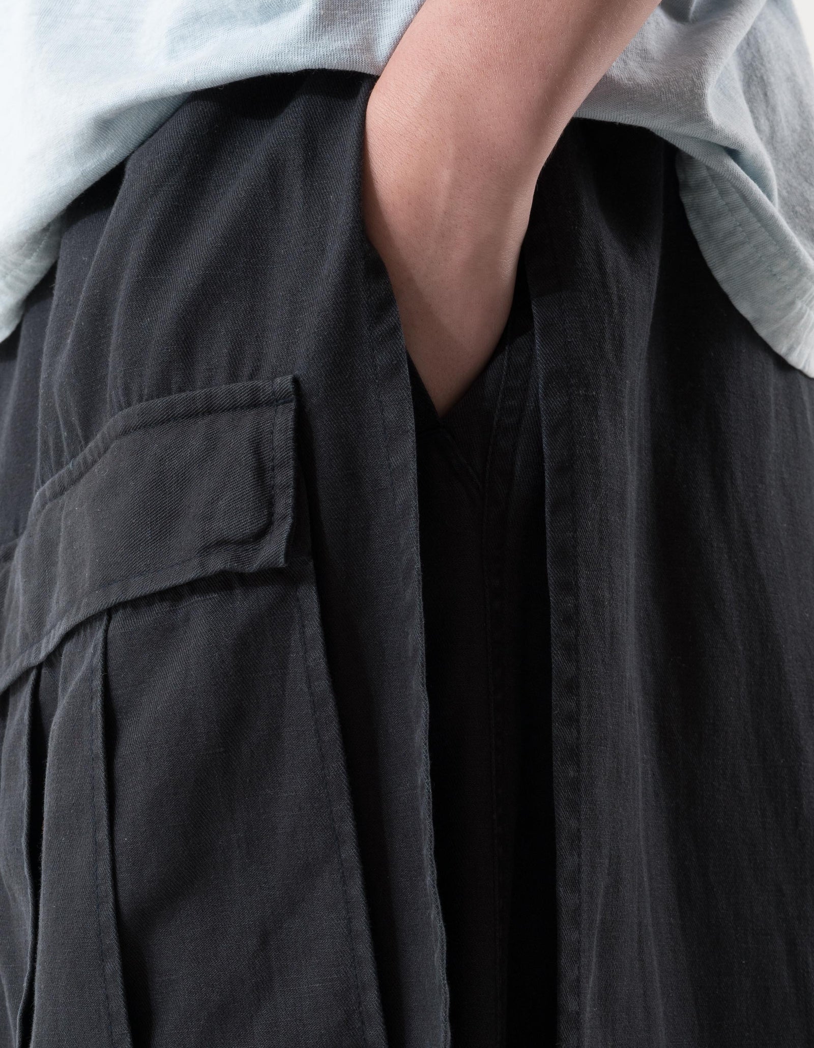 Person wearing dark cargo pants with a light gray shirt.