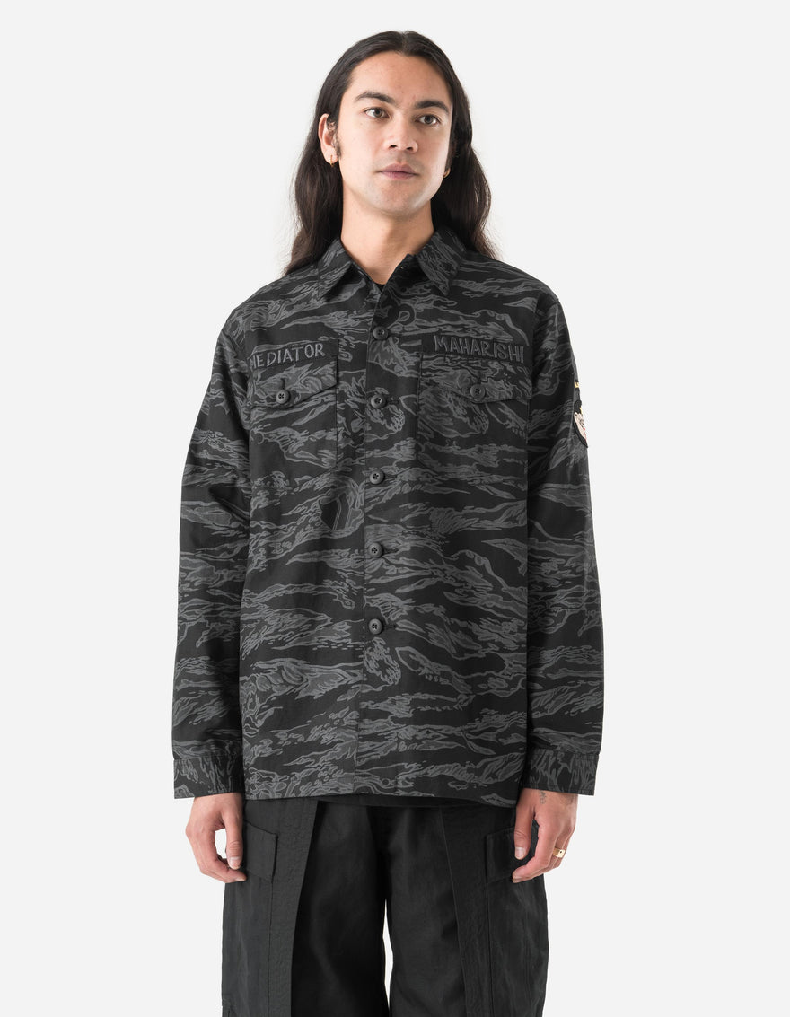 Person wearing a dark camouflage jacket on a white background