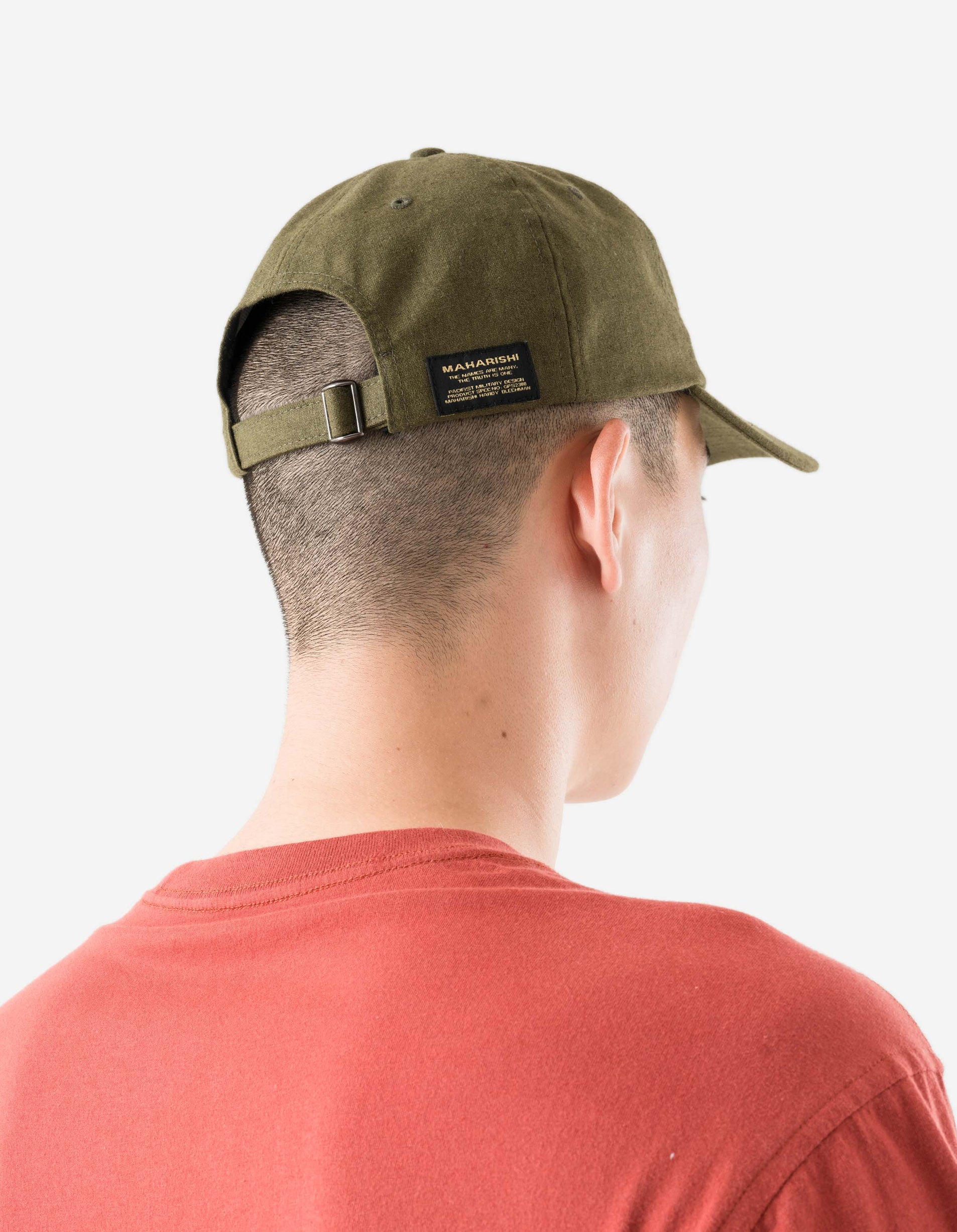 Person wearing a green cap with a brand logo on a white background