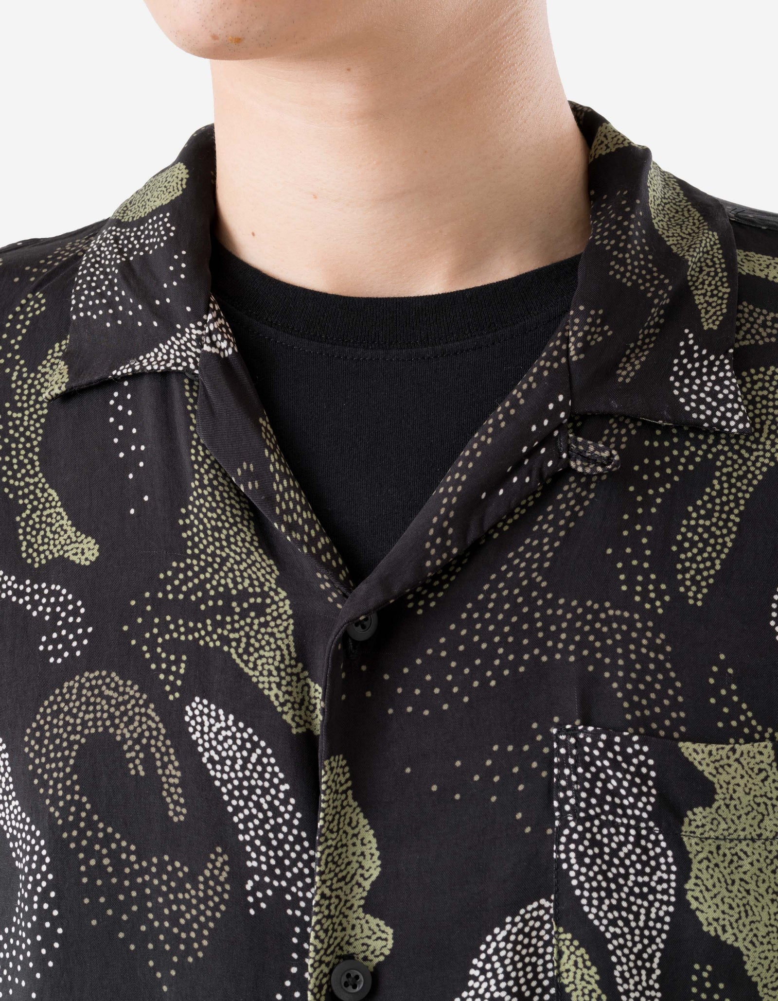 Close-up of a person wearing a black shirt with a patterned collar.