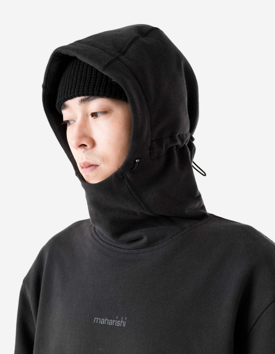 Person wearing a black hoodie with a brand logo on a light gray background