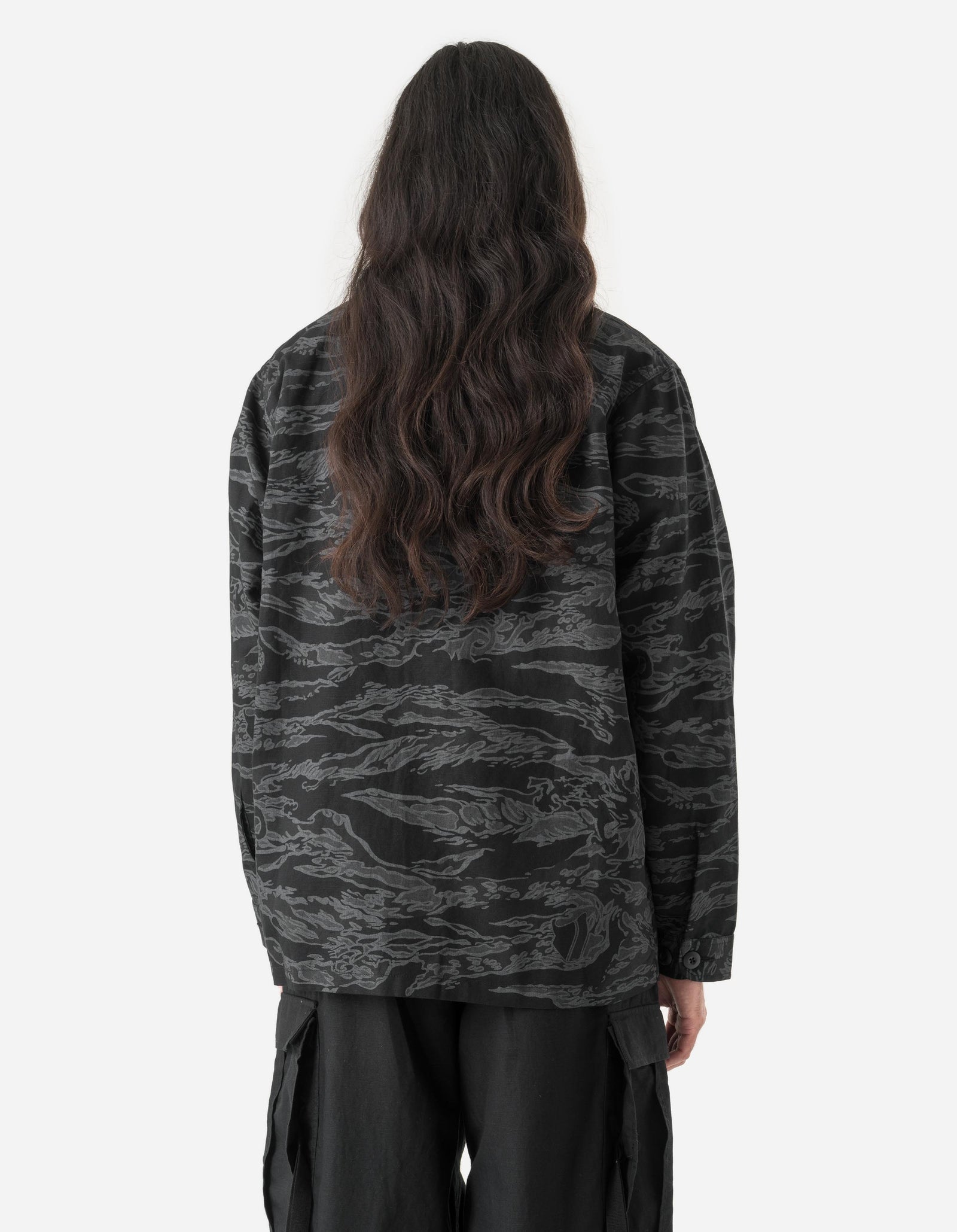 Person wearing a camouflage jacket on a white background