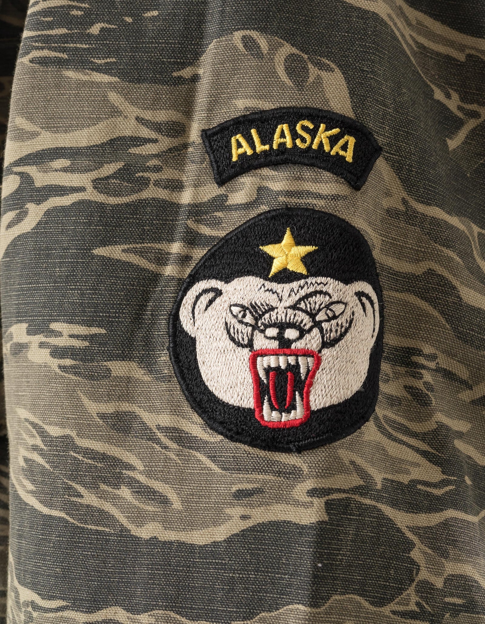 Camouflage fabric with 'Alaska' patch and bear head design
