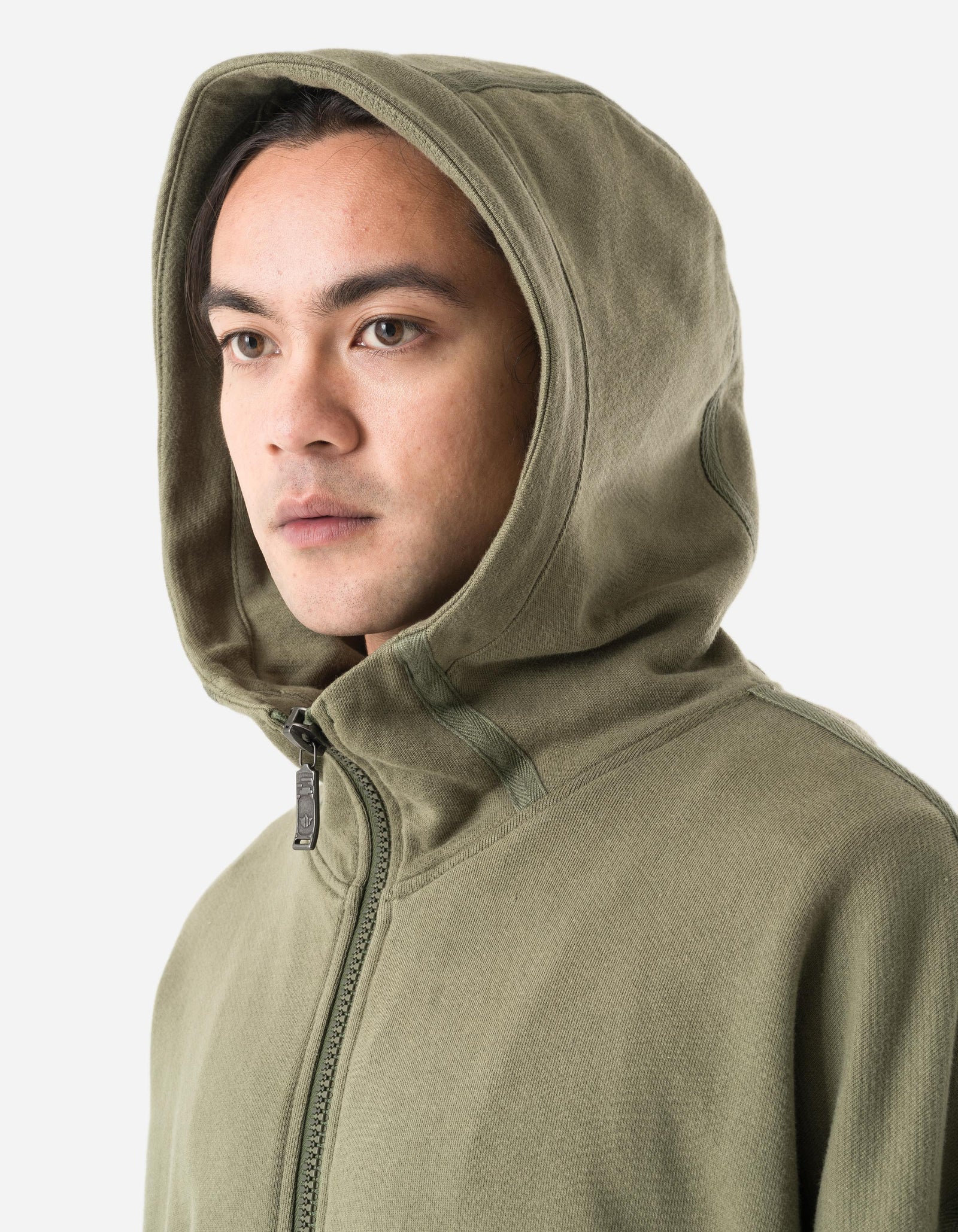 Person wearing a green hoodie with a zipper on a light gray background