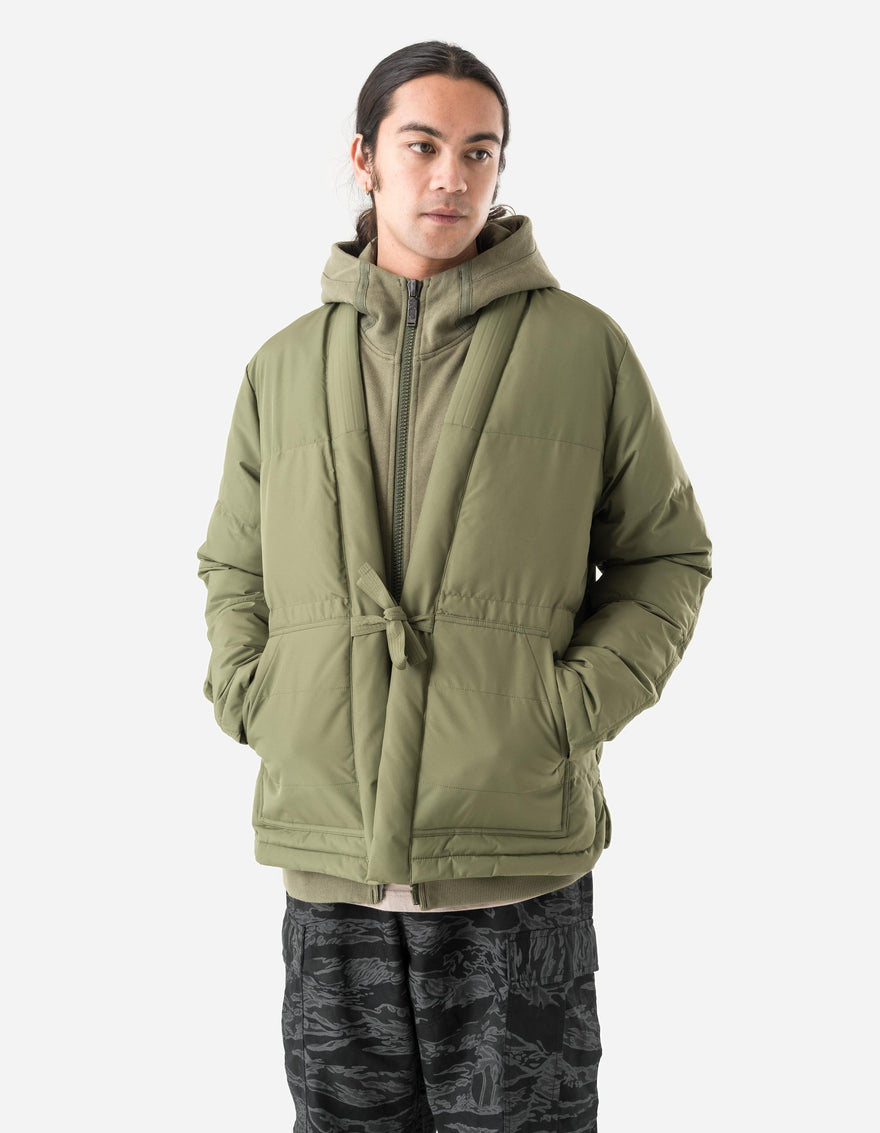 Person wearing a green puffer jacket on a white background