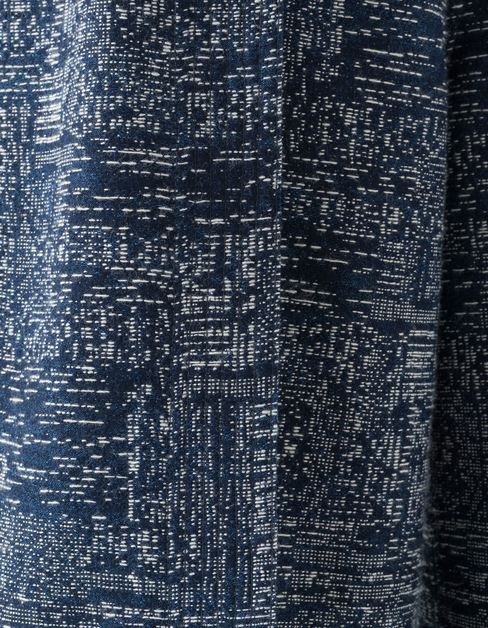 Close-up of a textured navy fabric with a subtle pattern on hakama trousers made by Maharishi