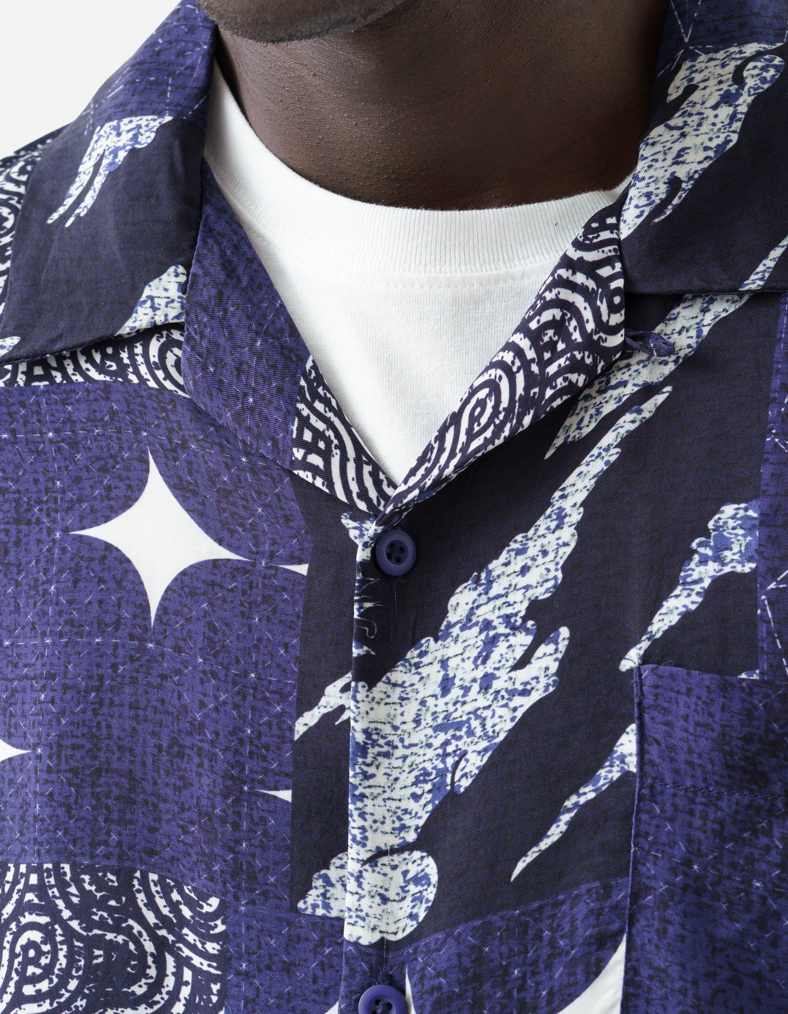 Close-up of a person wearing a blue patterned shirt with a white collar.