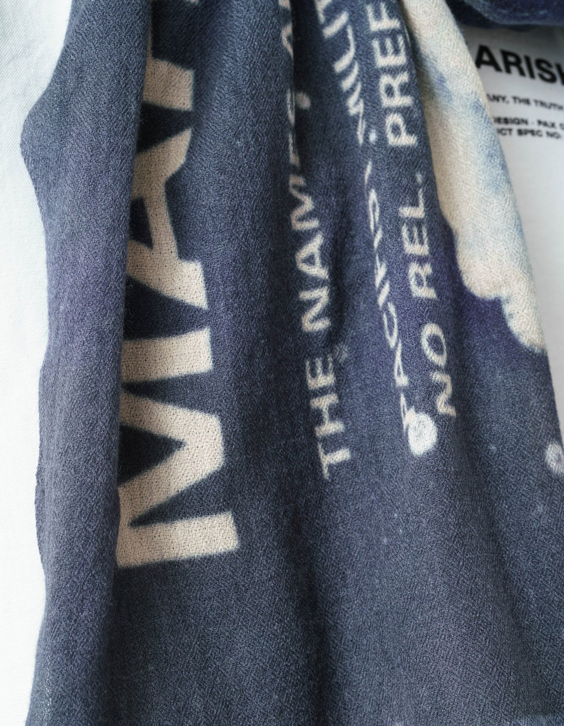 Close-up of a dark blue fabric with text and logos.