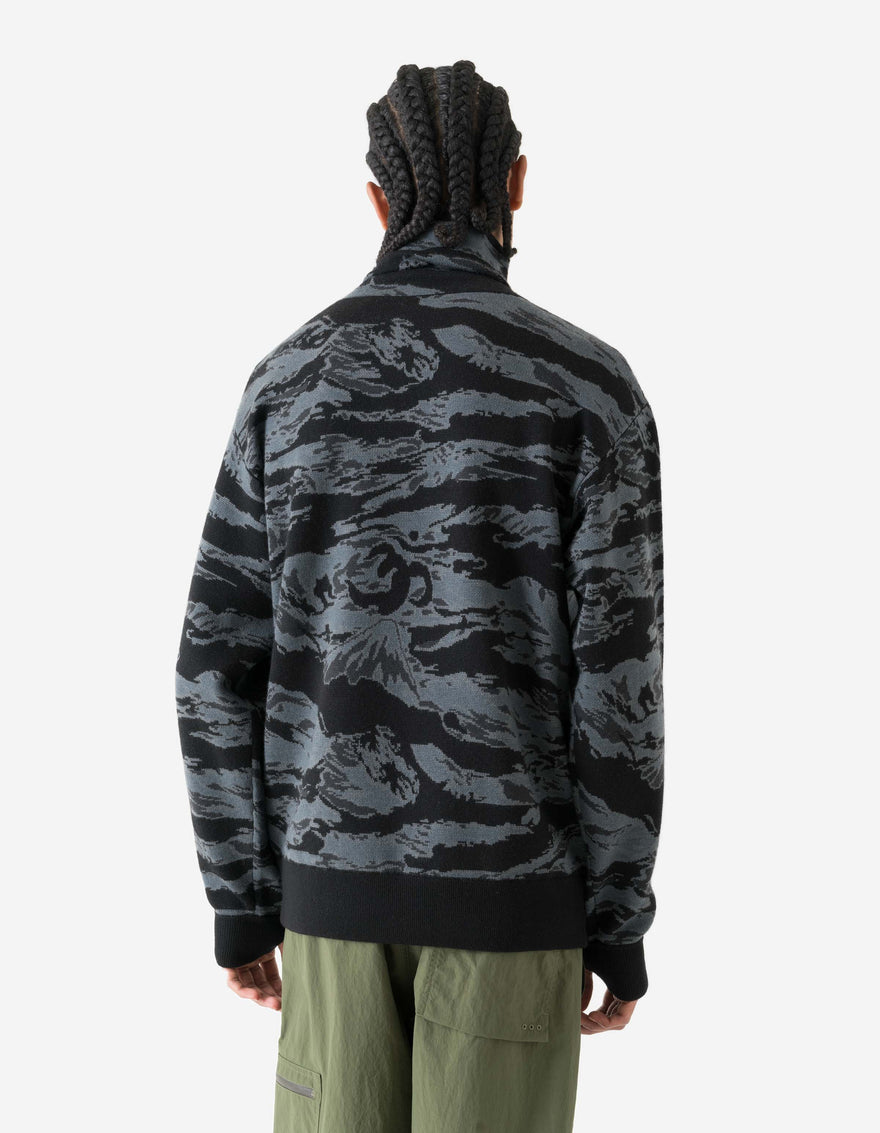 Person wearing a camouflage sweater on a white background