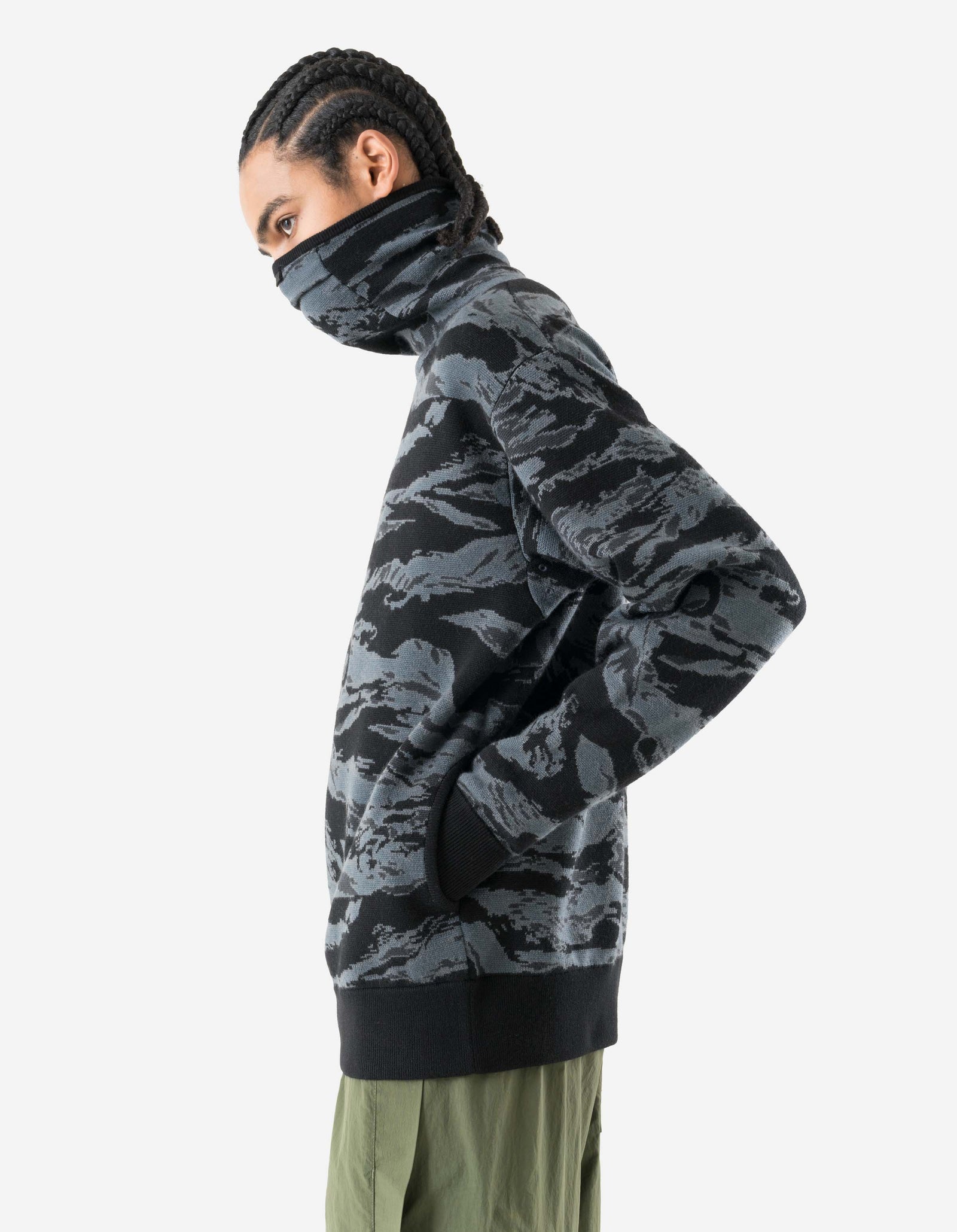 Person wearing a camouflage sweater on a white background