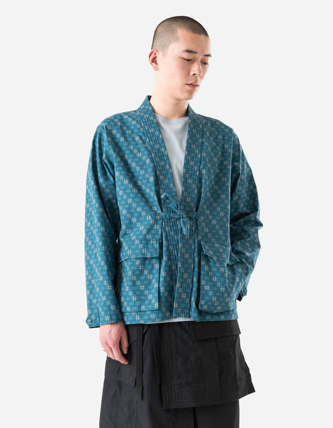 Person wearing a blue patterned jacket over a white shirt on a white background