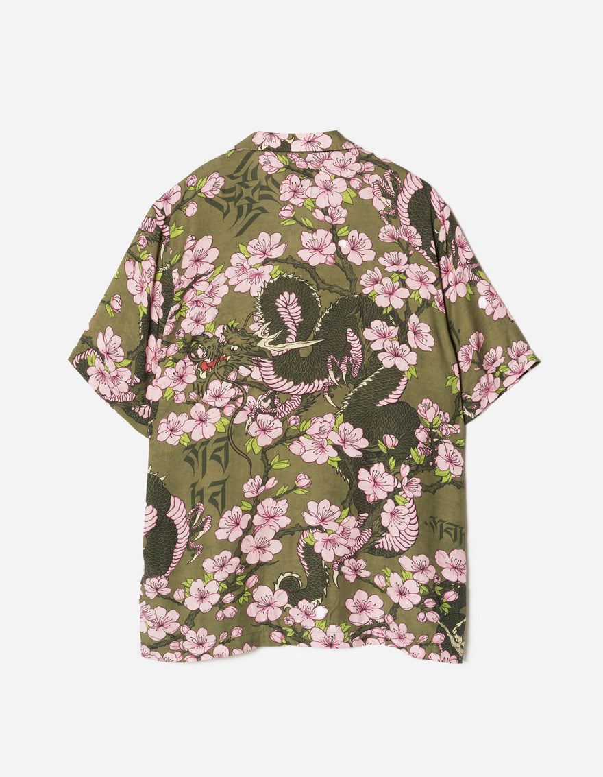 Floral patterned shirt with pink flowers and green leaves on a white background