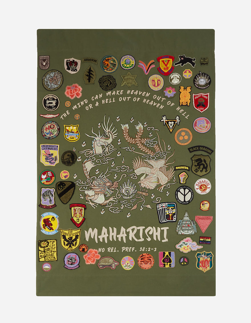A decorative tapestry with a green background featuring a dragon, along with various colorful badges and patches with different designs and texts.